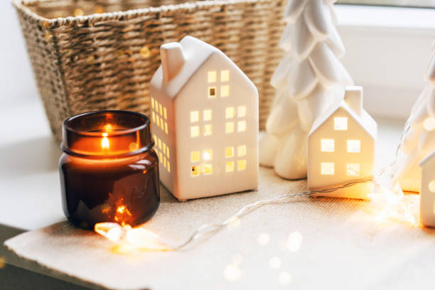 istock Cozy Christmas Scene with Ceramic Houses and Candlelight by a Window 2189646811
