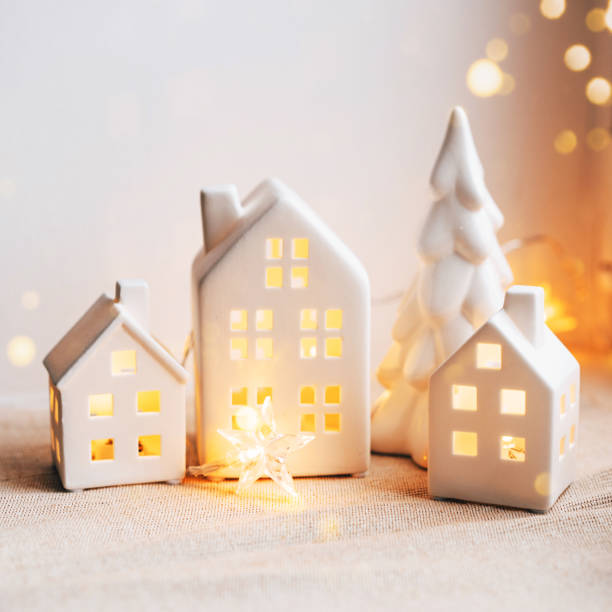 istock Cozy Christmas Scene with Ceramic Houses and Candlelight by a Window 2189646819