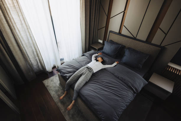 istock Tired woman lying on bed in hotel 2189647097