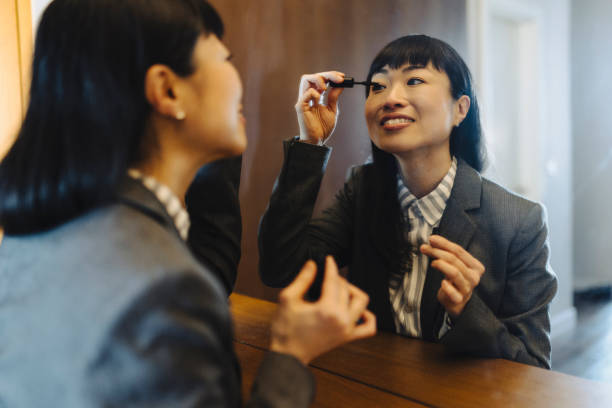 istock Businesswoman putting mascara, while observing herself in the mirror 2189647108