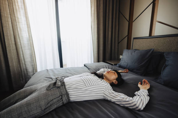 istock Tired woman lying on bed in hotel 2189647445