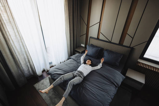 istock Tired woman lying on bed in hotel 2189648042