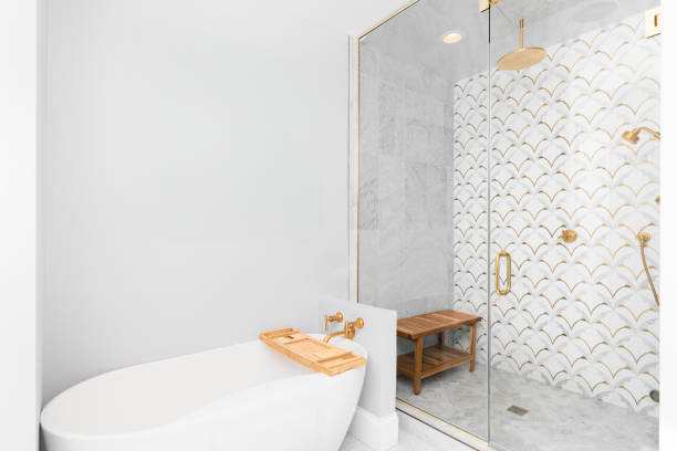 istock A bathroom's soaking tub and marble and gold tiled shower. 2189648755