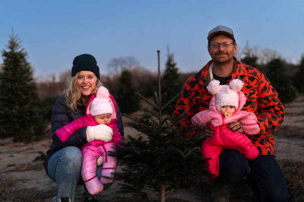 istock Parents hold twin baby daughters at a Christmas tree farm 2189649549