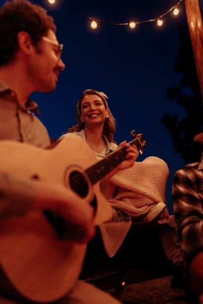 istock Close up photo of a man playing a guitar under string lights 2189650978