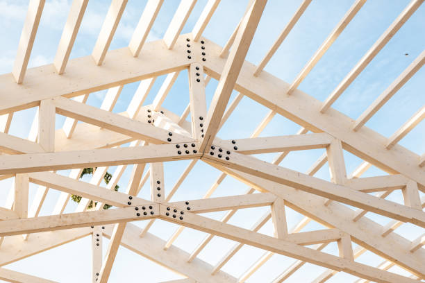 Wooden Roof Truss Structure Under Construction Against Blue Sky