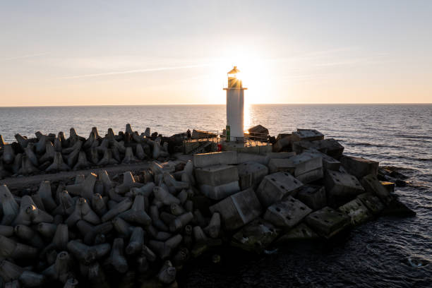 istock Lighthouse Silhouette at Sunset on Concrete Breakwater 2189654744