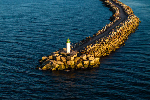 istock Lighthouse with Green Top on Curving Breakwater in Deep Blue Water 2189654751