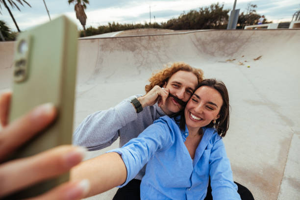 istock Playful couple taking a selfie in a skatepark 2189655420