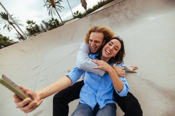 istock Young couple taking a selfie in a skate park 2189655423