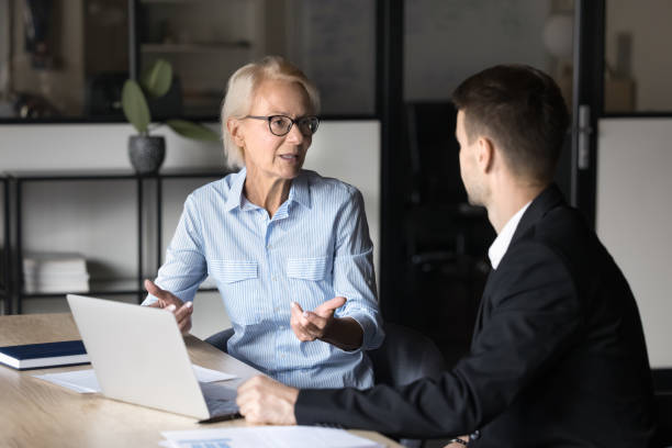istock Older businesslady provide explanations, share ideas or solution with colleague 2189658034