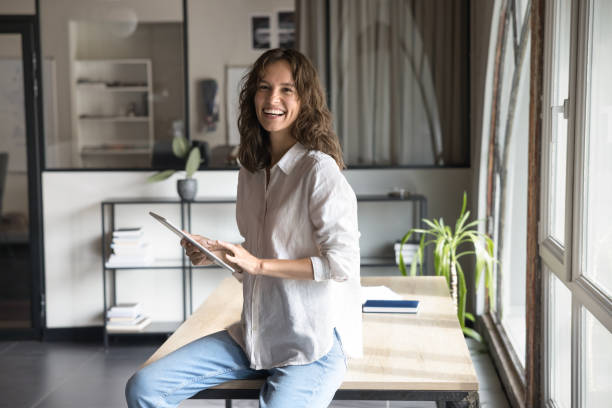 Happy woman working on tablet in modern workspace