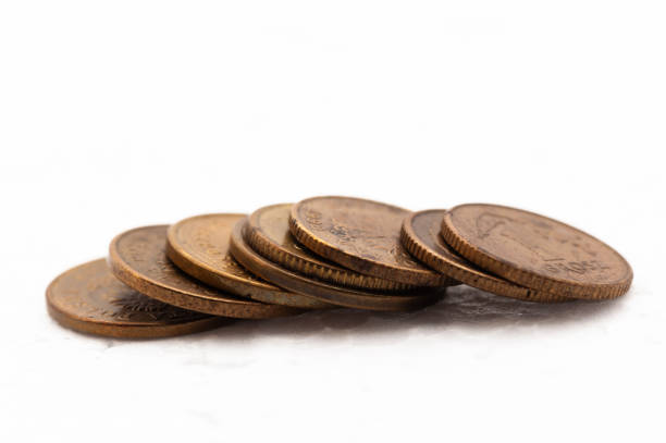 A stack of coins with the top one being a quarter. The coins are stacked on top of each other