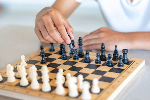 istock Asianboy is playing chess games on mini wooden chessboard 2189659233