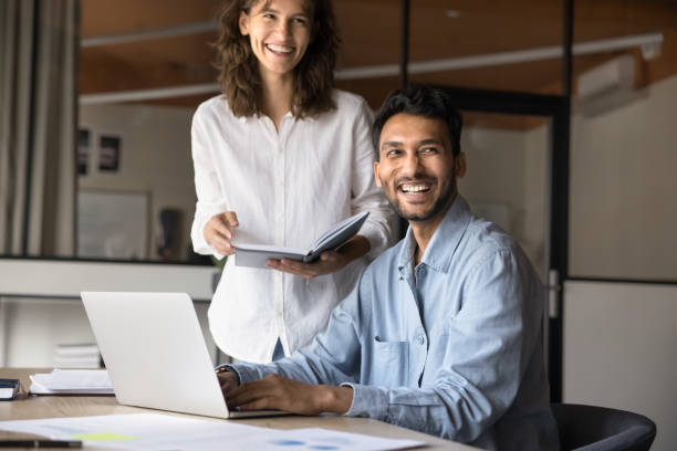istock Two joyful Hispanic and Indian teammates working on joint task 2189659872