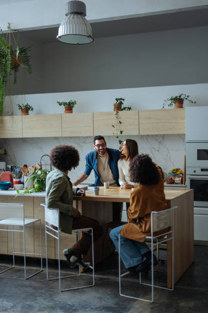 istock Cheerful friends enjoying coffee and conversation in modern kitchen 2189664198