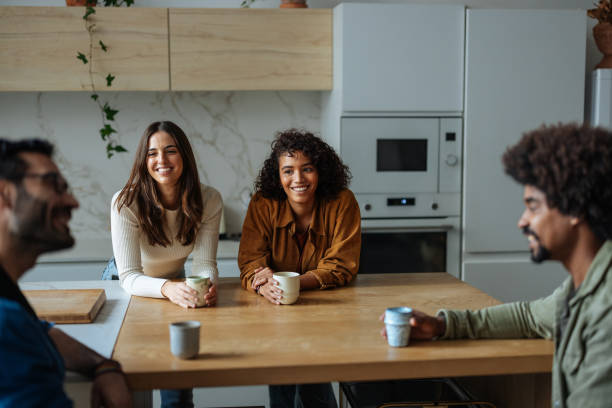 istock Cheerful young adults enjoying coffee and conversation in kitchen 2189664199