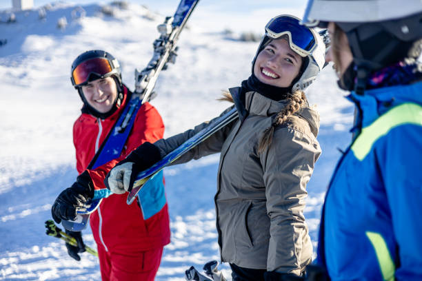 istock Three cheerful friends walking with ski equipment 2189664920