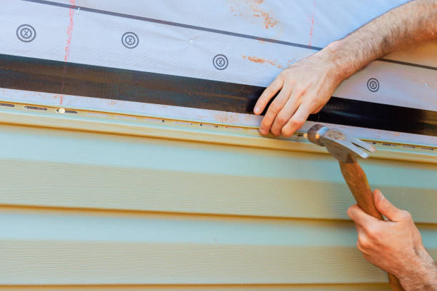 istock Hands working on house siding installation with hammer and protective materials during daytime 2189665548