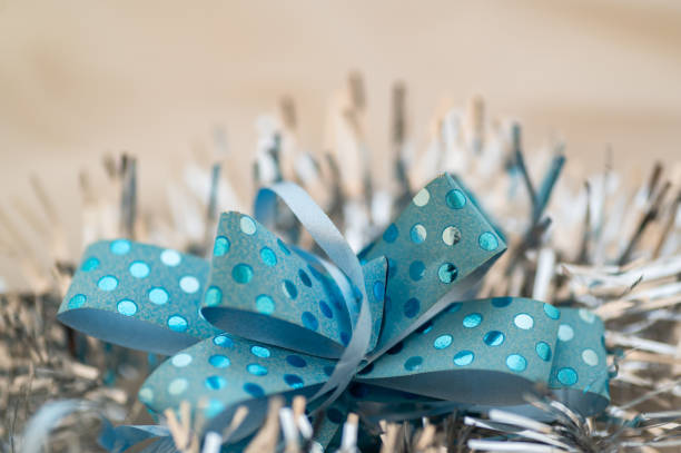 Gift box tied with satin pale green ribbon on a light gray paper background. copy space, place for text,