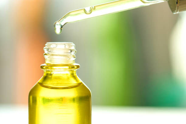 istock Dropping serum collagen moisturizer of face into clear yellow bottle soft light background. Protector skin Treatment facial essence oil, Vitamin C. Beauty and spa Concept. 2189686344