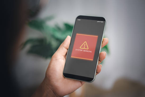 istock Woman shows smartphone with system hacked alert on screen. Compromised information concept. Internet virus cyber security and cybercrime. Concepts of system maintenance, Access to critical data. 2189692476