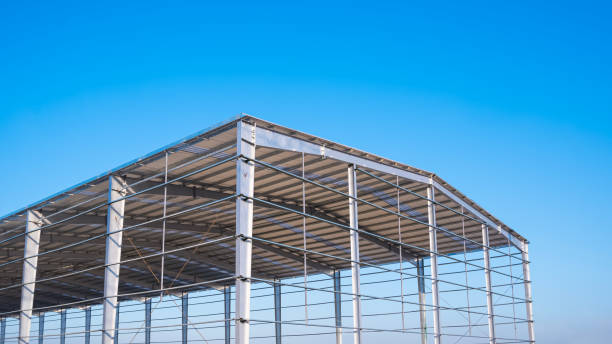 istock Factory building framework with metal post structure and gable roof in construction site against blue sky background 2189696531