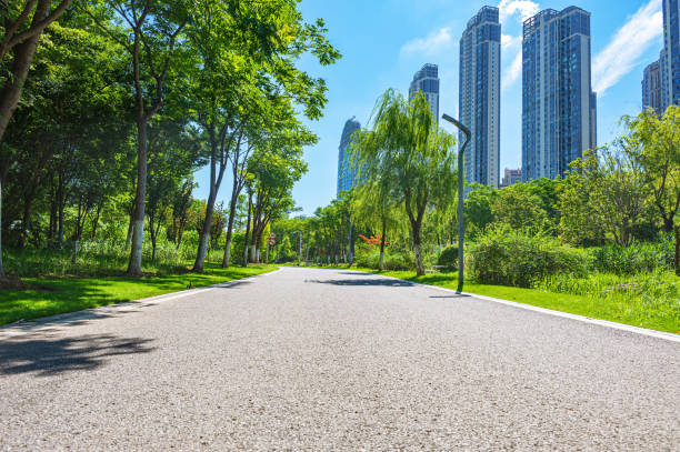 istock Curved asphalt road through the green city park 2189697874