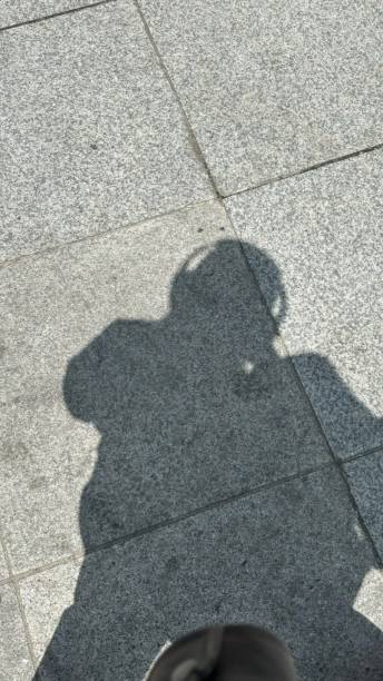 istock The silhouette of a person cast on a textured surface, their form slightly distorted by the angle of light. The shadow creates a mysterious and intriguing composition. 2189704454