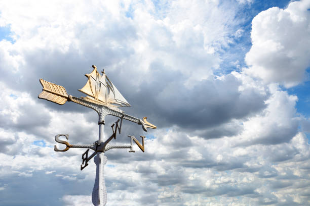 Sailboat weather vane against blue sky with copy space.