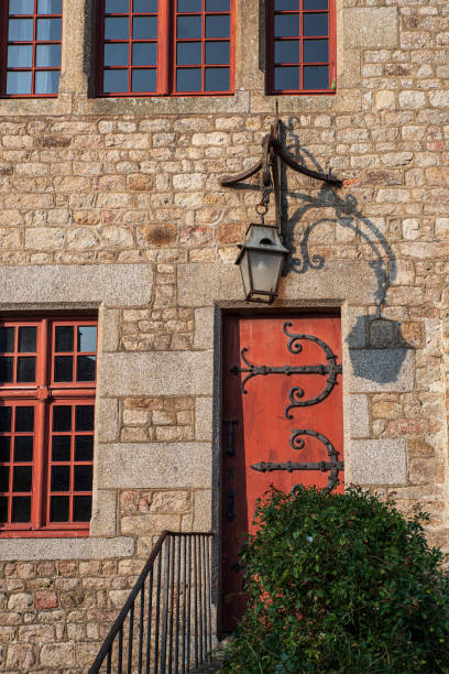 Detail of red wooden entrance door with wrought iron from a house on Mont Saint-Michel in Normandy, France