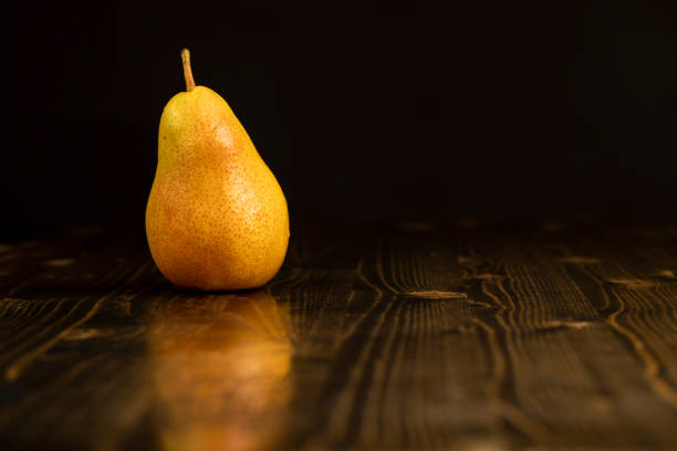one fresh red pear with yellow color on the table, closeup of a pear, close up