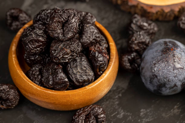 istock ripe purple plums and dried plums 2189710780