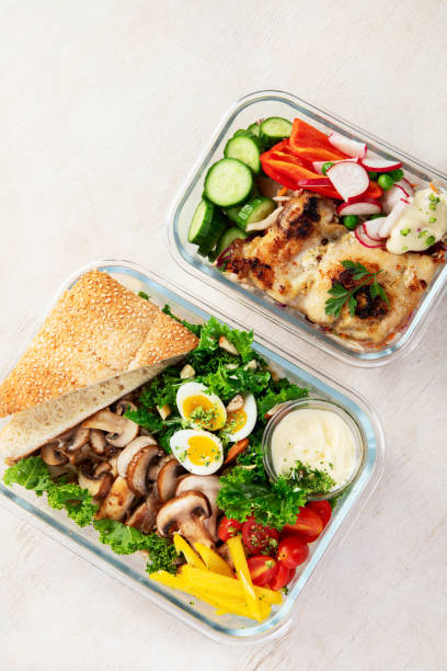 istock Lunch box containers with grilled chicken breast and fresh vegetable salad. 2189710833