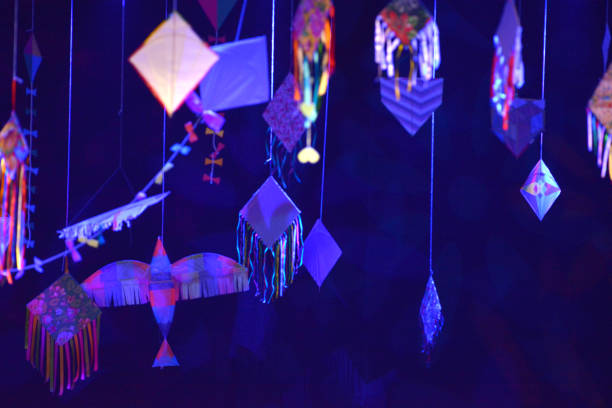 cluster of flying kites, dark background, studio photo