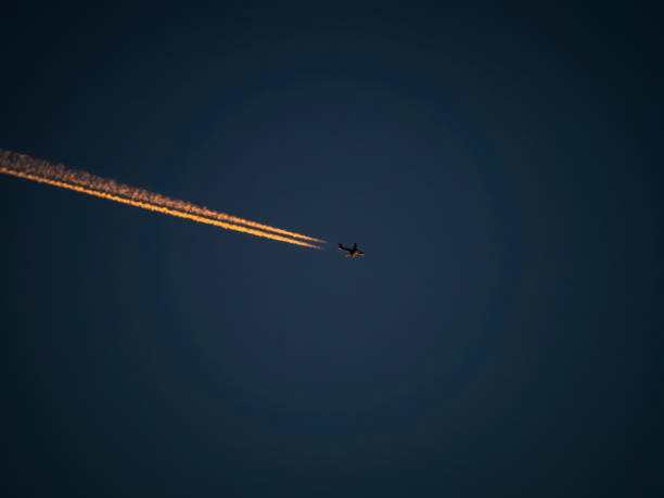 istock Airplane trails over sky at sunset polluting the atmosphere 2189727219