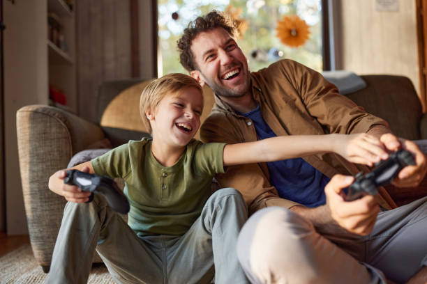 istock Cheerful father and son playing video games at home. 2189732543