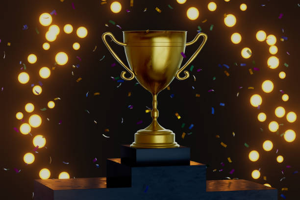 istock A gold cup is on top of a podium with confetti falling around it 2189733719