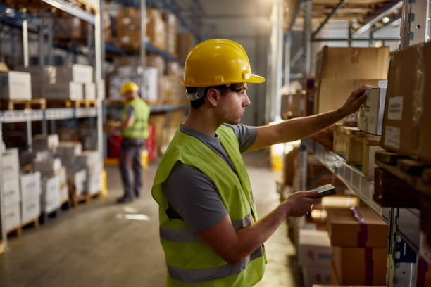 istock Young manual worker scanning packages in storage room. 2189738296