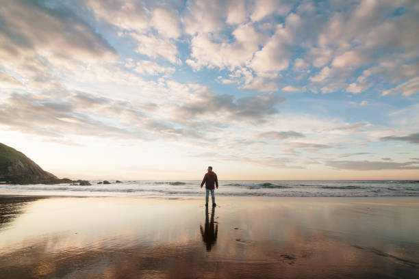 istock Silhouette of a man on a beach at sunset 2189738769