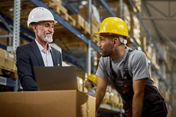 istock Happy senior manager and worker working on laptop in distribution warehouse. 2189739012
