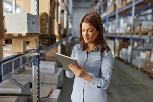 istock Female inspector surfing the Internet on touchpad in storage room. 2189739783