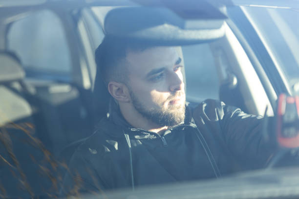 istock A handsome man sits focused behind the wheel, driving a car 2189743301
