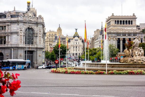 Madrid, Spain; 09-20-2024: View of Cibeles statue from behind, Gran Vía, Alcalá street, Bank of Spain building, and iconic Metropolis building, with traffic in Madrid