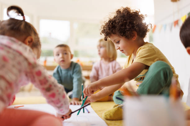 istock Boy drawing whit his friends in kindergarten 2189747761