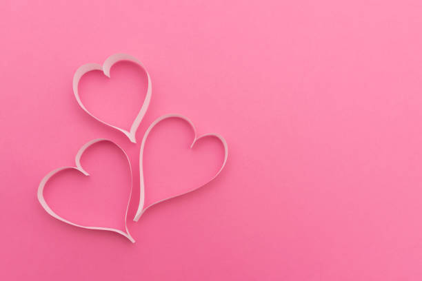 istock Three white paper hearts lying on a pink background represent valentine's day love and romance 2189748320