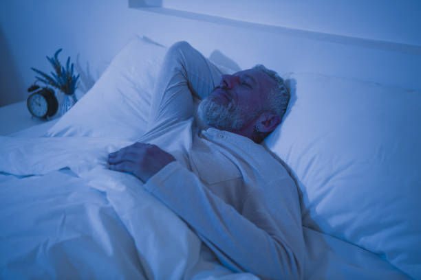istock Elderly man with grey hair peacefully resting in comfortable bed during night, enjoying leisure time 2189748524