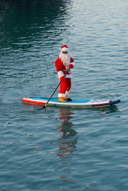 istock Santa in sunglasses stand on paddle board. Christmas, New Year 2189751229
