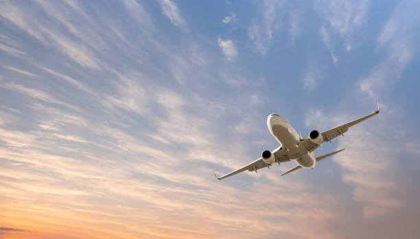 istock Airplane flying over tropical sea at sunset 2189752035