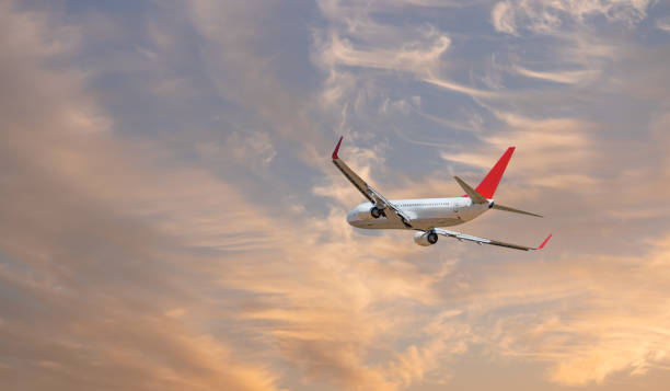 istock Airplane flying over tropical sea at sunset 2189752718